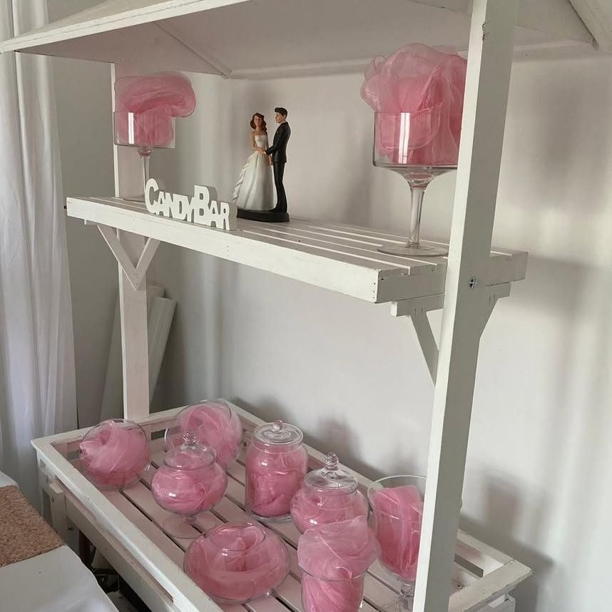 Candy bar blanc avec bonbonnières roses et figurine de mariés